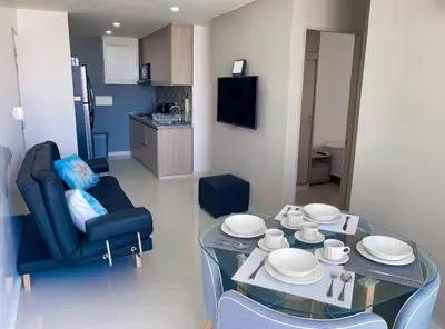 a living room with a glass table and a chair at Hermoso apto, cerca al mar in Cartagena de Indias