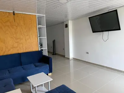 a living room with a blue couch and a flat screen tv at Club House in Maizal