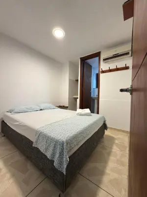 a bedroom with a bed in a room with a door at Hostal El Recreo in Barranquilla