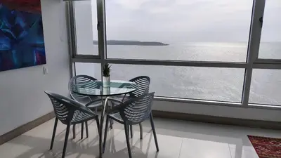 a glass table and chairs in a room with a window at Palmetto Sunset in Cartagena de Indias