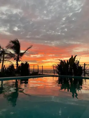 a swimming pool with a sunset in the background at Serenity Home in San Bernardo del Viento