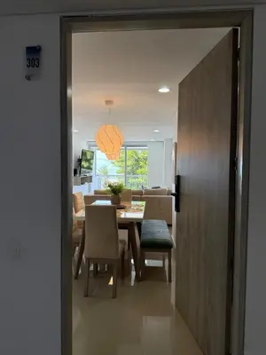 a dining room and living room with a table and chairs at Hermoso apartamento moderno con vista al mar in Cartagena de Indias