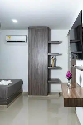 a bedroom with a bed and a wooden cabinet at Hotel Brisas in Tierra Bomba