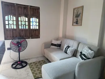 a living room with a couch and a fan at Cactus Beach Stay APARTAMENTO in Santa Marta