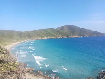 a view of a beach with mountains in the background at Cactus Beach Stay APARTAMENTO in Santa Marta