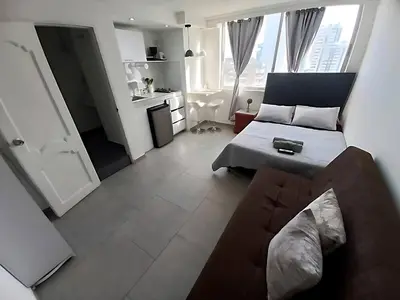 a living room with a couch and a kitchen at PISO 12 Cerca a la playa, Piscina, Wifi, AC in Cartagena de Indias