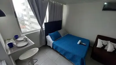 a small bedroom with a blue bed and a sink at PISO 12 Cerca a la playa, Piscina, Wifi, AC in Cartagena de Indias