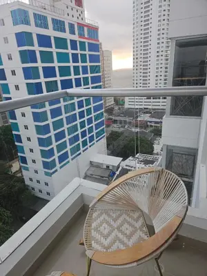 a chair on a balcony with a view of a city at Bocagrande Urban loft in Cartagena de Indias