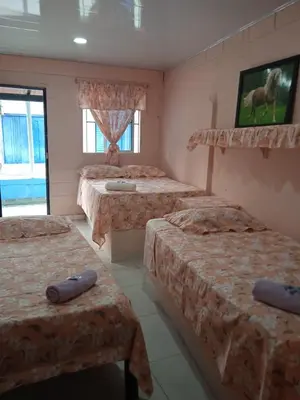 a room with four beds in a room at Hotel Doña Edita in San Bernardo del Viento