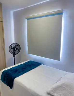 a bedroom with a bed with a window and a fan at Espectacular vista a la Ciudad in Cartagena de Indias