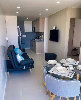 a living room with a table and chairs and a kitchen at Espectacular vista a la Ciudad in Cartagena de Indias