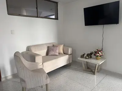 a living room with a couch and a table with a tv at Apartamento central en Barranquilla in Barranquilla