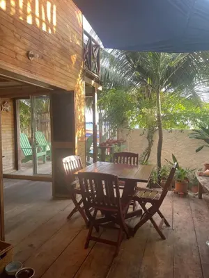 a wooden table and chairs on a patio at Cabaña la bota in Rincón
