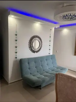 a blue couch in a living room with a mirror at Cómodo y Comfortable Apto in Cartagena de Indias