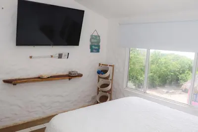 a bedroom with a flat screen tv on the wall at Serenity by the Sea in Juan de Acosta