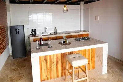 a kitchen with a sink and a counter with a stool at Arumake in Turbaco