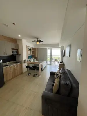 a living room with a couch and a kitchen at Crespo Horizon Suite in Cartagena de Indias