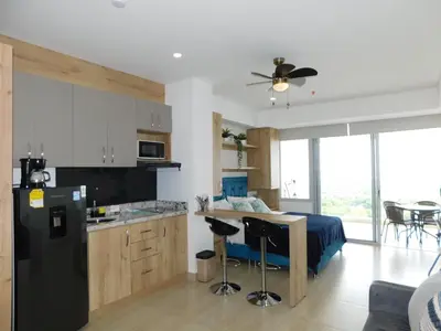 a kitchen with a black refrigerator and a bed at Crespo Horizon Suite in Cartagena de Indias