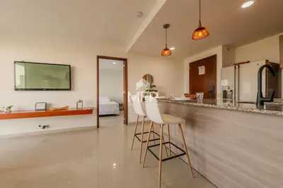 a kitchen with a bar with two white bar stools at Edificio Morros Vitri, 2 Bedrooms- Comfy Apartment in Cartagena de Indias