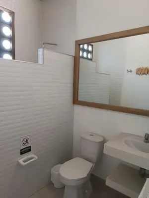 a bathroom with a toilet and a sink and a mirror at Playa del Toro in El Bobo