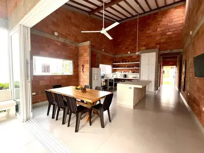 a kitchen and dining room with a wooden table and chairs at Playa del Toro in El Bobo