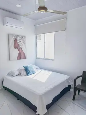 a white bedroom with a bed and a window at Cabañas El Laguito Coveñas in Coveñas
