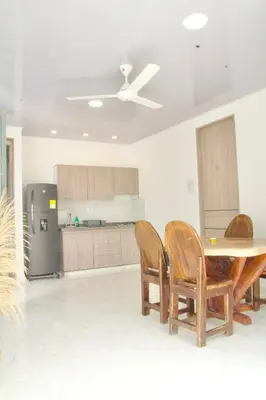 a kitchen with a table and chairs and a refrigerator at Cabañas El Laguito Coveñas in Coveñas