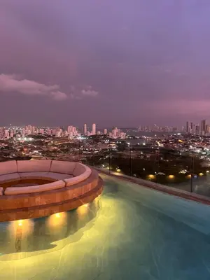 a swimming pool with a city skyline at night at Murano Centro1 26floor,rooftop,infinity pool & views byIMZ in Cartagena de Indias