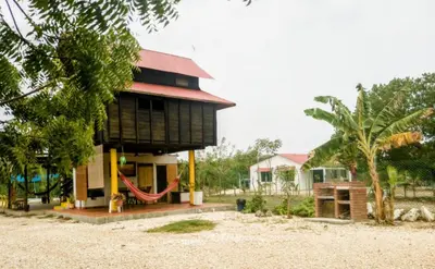 a house on the beach with a hammock in front at La casa en el Aire in San Antero