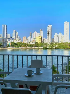 a table with two cups on a balcony with a view of a city at apartamento con vista al Lago in Cartagena de Indias