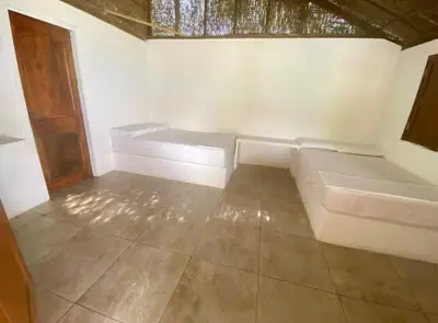 a white couch sitting in a room with a tile floor at Agua Zalada in Isla Grande