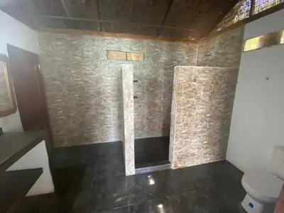 a bathroom with a shower with a brick wall at Agua Zalada in Isla Grande