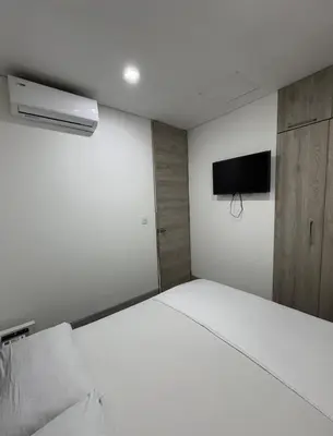 a bedroom with a white bed and a tv on the wall at Espectacular Apartamento Amoblado - 2 Habitaciones in Barranquilla