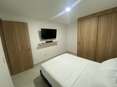a bedroom with a bed and a flat screen tv at Apartamento Sabaii 201 in Cartagena de Indias