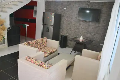a living room with two chairs and a refrigerator at Cabaña AveMaria in Coveñas