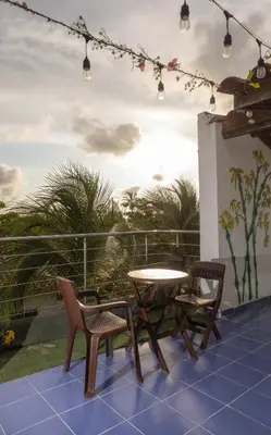 a patio with a table and chairs on a balcony at Cabaña AveMaria in Coveñas