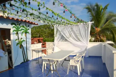 a patio with a white table and chairs on a roof at Cabaña AveMaria in Coveñas