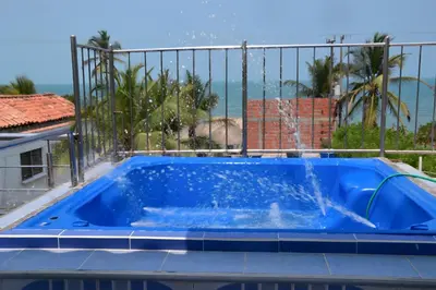 a blue swimming pool with a view of the ocean at Cabaña AveMaria in Coveñas
