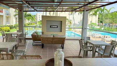 a patio with tables and chairs and a pool at Apartamento Descanso Cartagena in Manzanillo del Mar