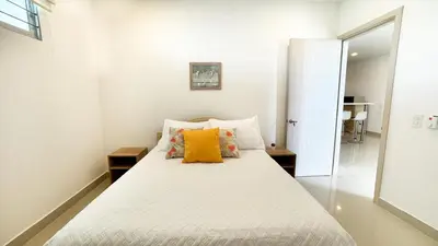 a white bedroom with a bed with yellow pillows at Magico Apartamento Frente al Mar 3 Habitaciones AR12 in Coveñas