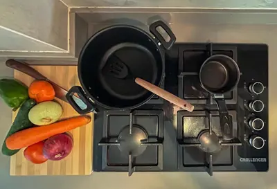 a stove with pots and pans and vegetables on it at Despierta en Tolú, un escenario de película in Tolú