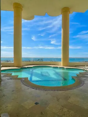 a swimming pool with columns and the ocean in the background at Cabrero Beach 1008 in Cartagena de Indias