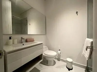 a white bathroom with a toilet and a sink at sui lofts 1609 in Santa Marta