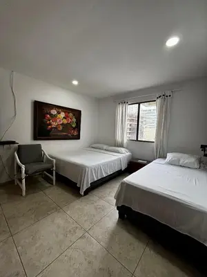 a bedroom with two beds and a chair in it at Apartamentos en Bocagrande frente al mar in Cartagena de Indias