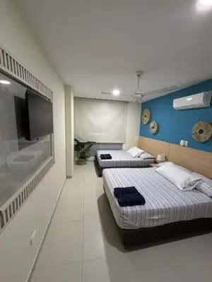 a room with two beds and a flat screen tv at Refugio junto al mar en el Cabrero in Cartagena de Indias