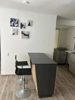 a kitchen with a black counter and a chair at Apartamento en Barranquilla in Puerto Colombia