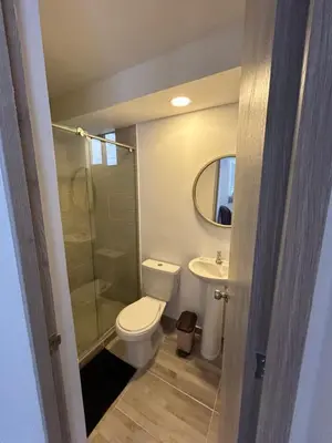 a bathroom with a toilet and a sink and a mirror at Apartamento en Barranquilla in Puerto Colombia