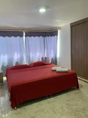 a bedroom with a red bed with two towels on it at PrinSha#2 in Cartagena de Indias