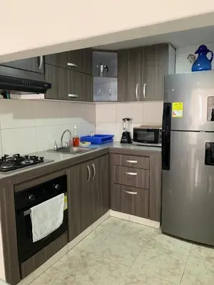 a kitchen with wooden cabinets and a stainless steel refrigerator at PrinSha#2 in Cartagena de Indias