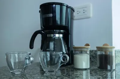 a coffee maker sitting on a counter with two cups at Luxury penthouse cerca al mar y centro historico in Cartagena de Indias